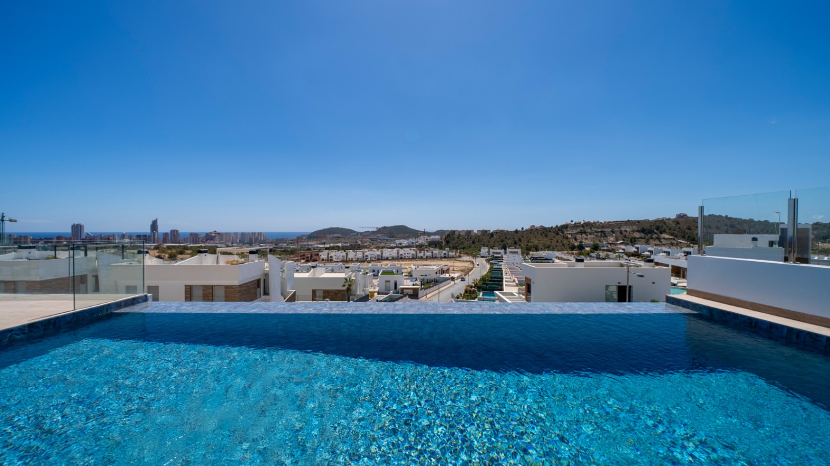 Villa moderne neuve avec piscine à débordement, ascenseur privé et vue sur la skyline de Benidorm.